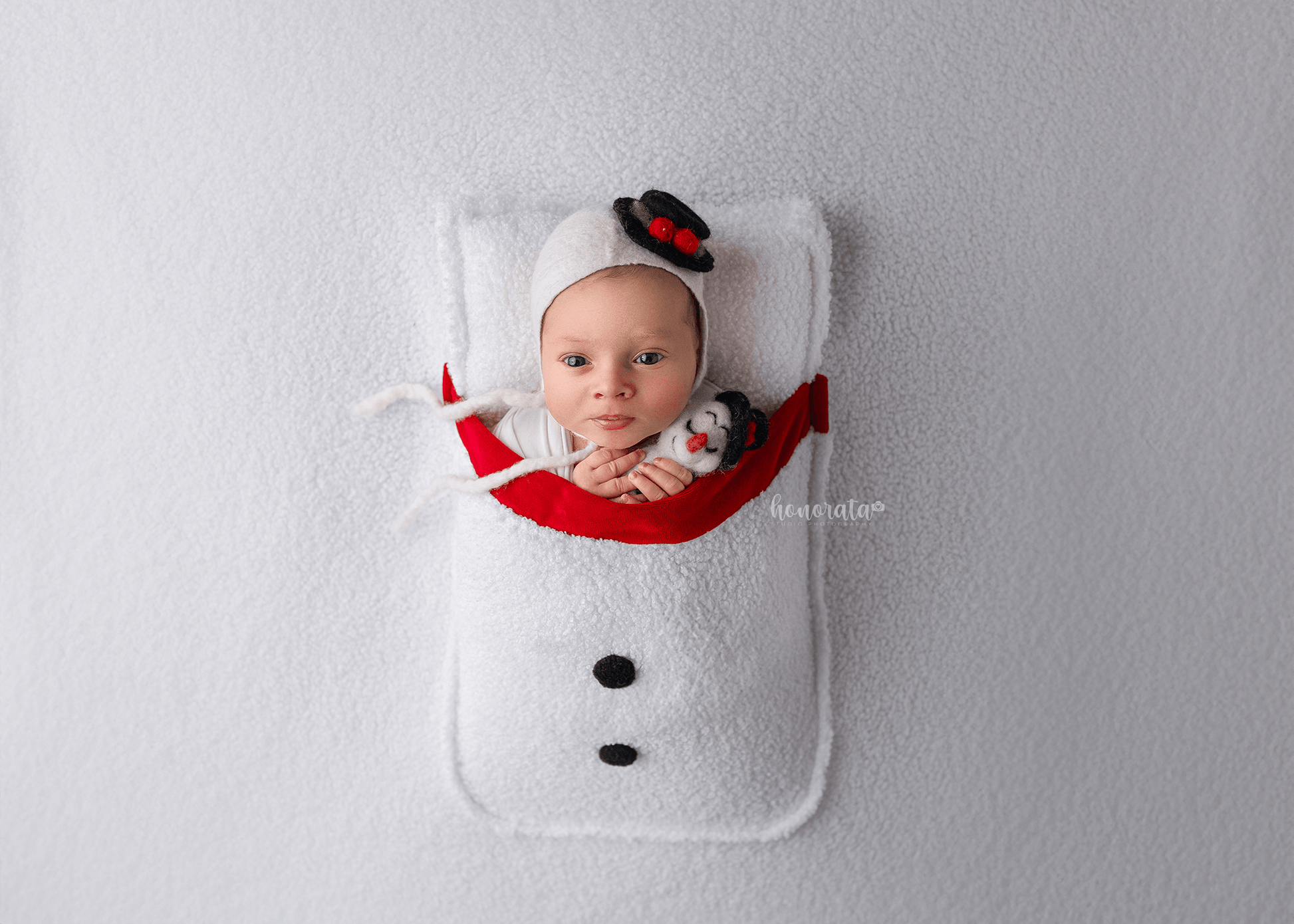 Snowman Backdrop with a pocket and snowman's hat. Newborn photo props featuring a baby in a snowman-themed setup.