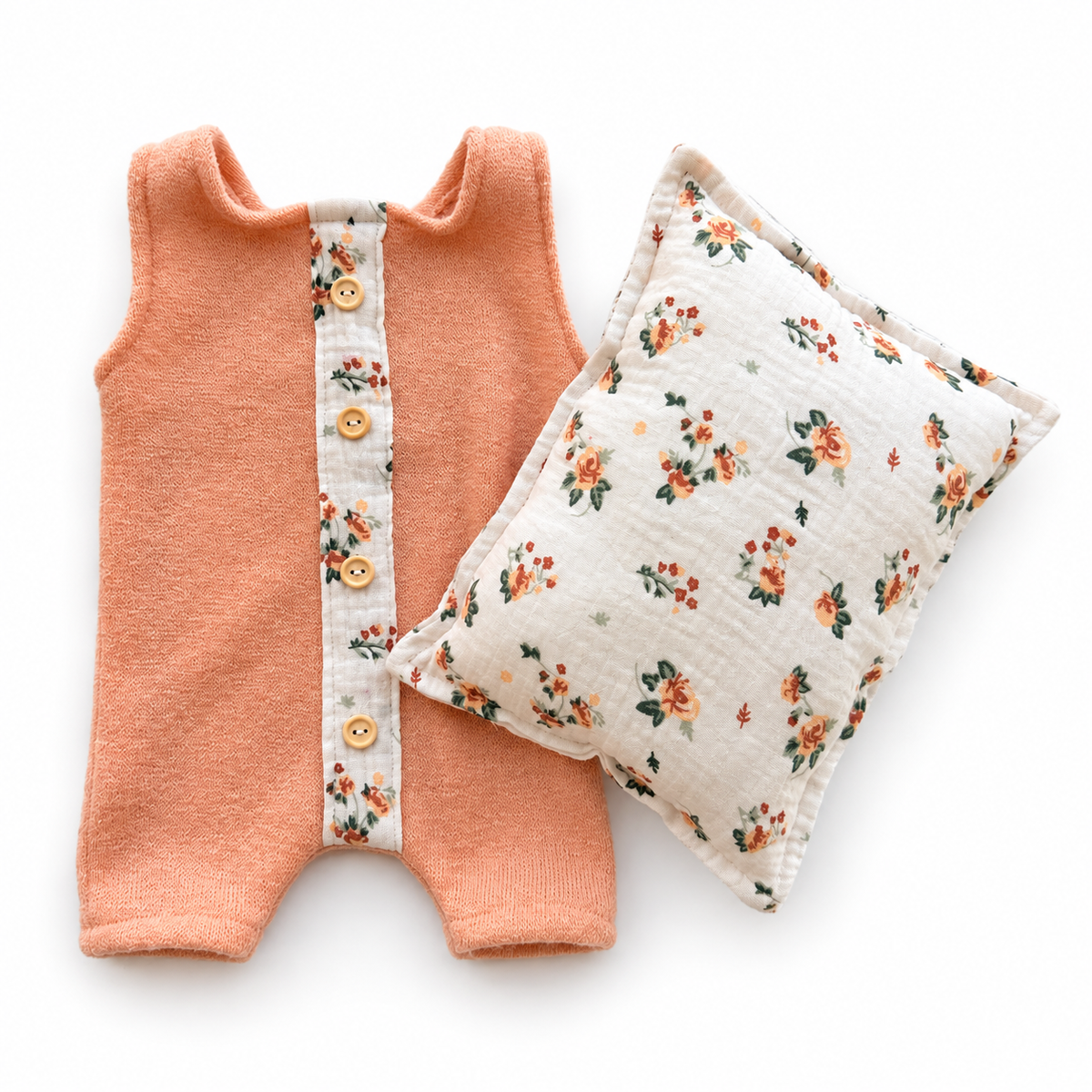 Peach newborn photography romper with floral button placket and matching floral posing pillow