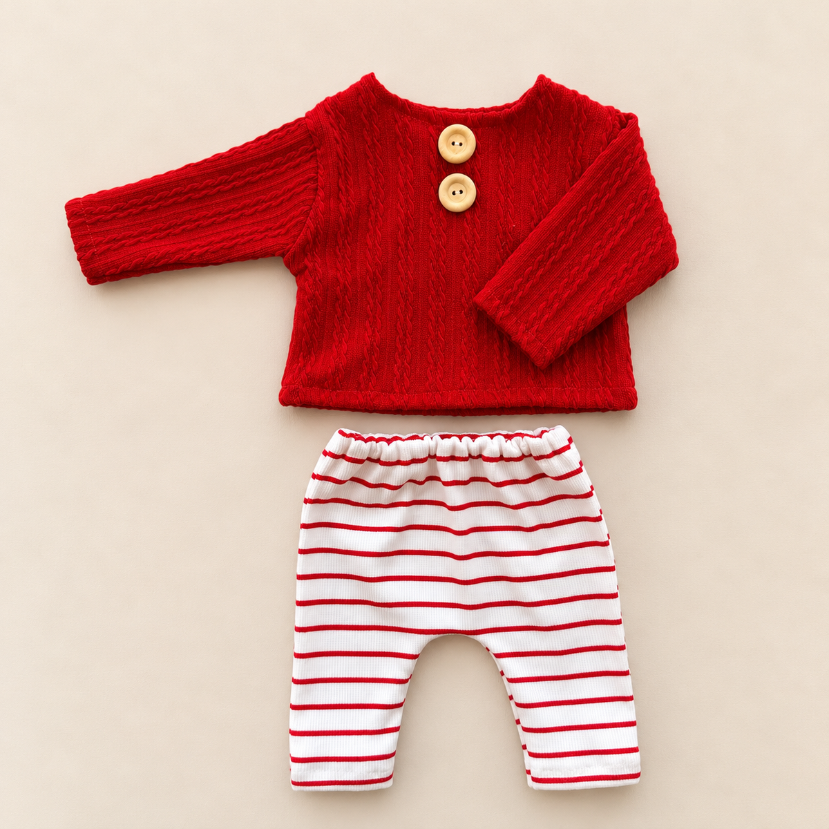 Christmas newborn photography outfit with red textured cable knit top and white pants with red stripes